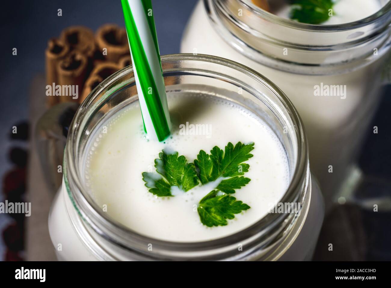 simple homemade kefir in a glass with spices and herbs on a gray background, copy space. Probiotic Ayran Stock Photo