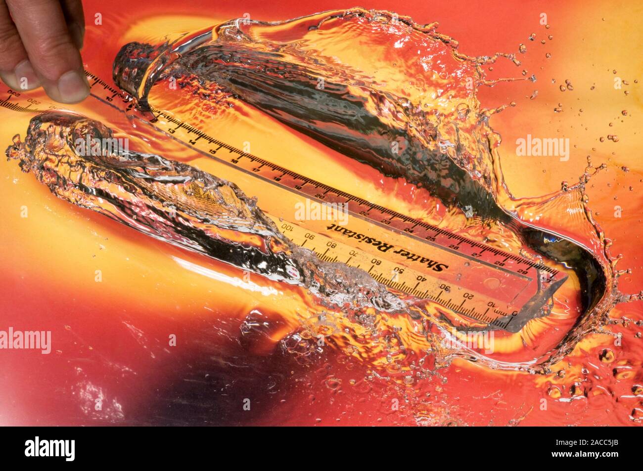 Ruler hitting water. High speed photograph of the spray produced as a ...