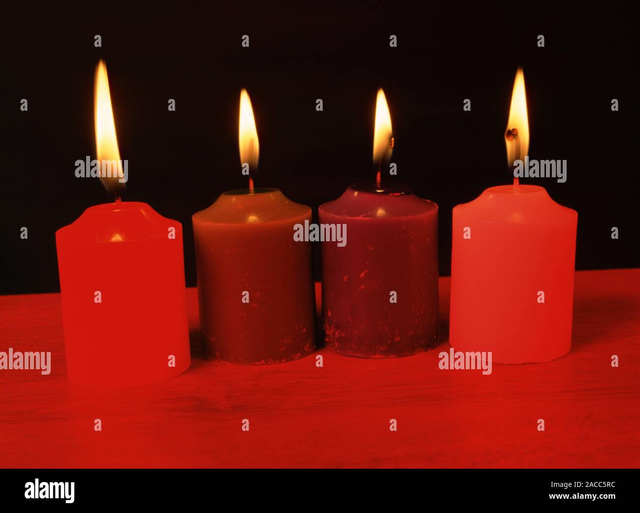 Candles under red light. Image 1 of 2. Colour is the result of an