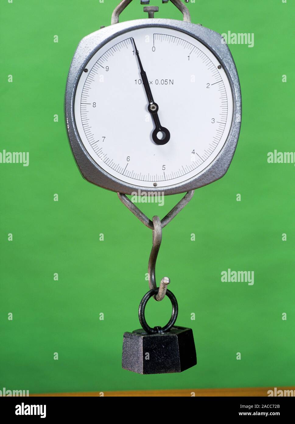 Mass and weight. One kilogram mass being weighed on a newtonmeter. Mass