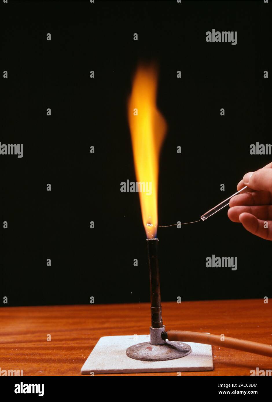 Flame test. Sodium burning in the flame of a bunsen burner producing an