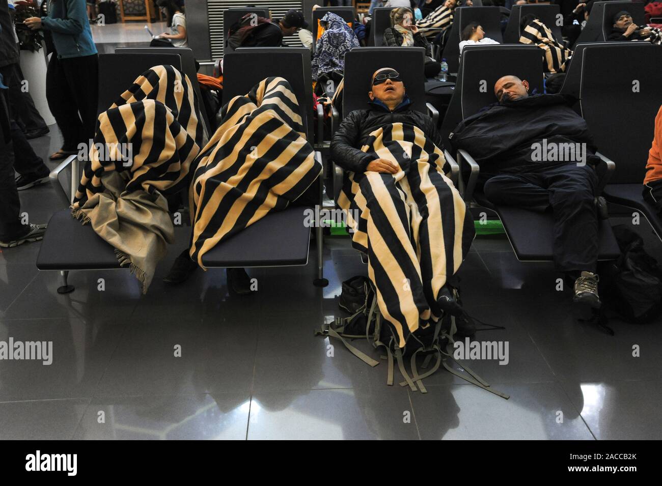 04.01.2014, Abu Dhabi, United Arab Emirates - Sleeping passengers wait for their connecting flights in the transit hall during a stopover. Stock Photo