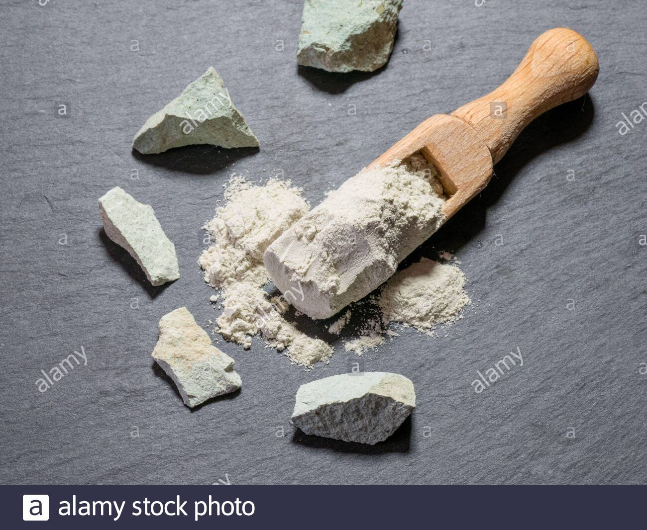 Zeolite Natural Raw Stones And Zeolite Powder On Black Stone