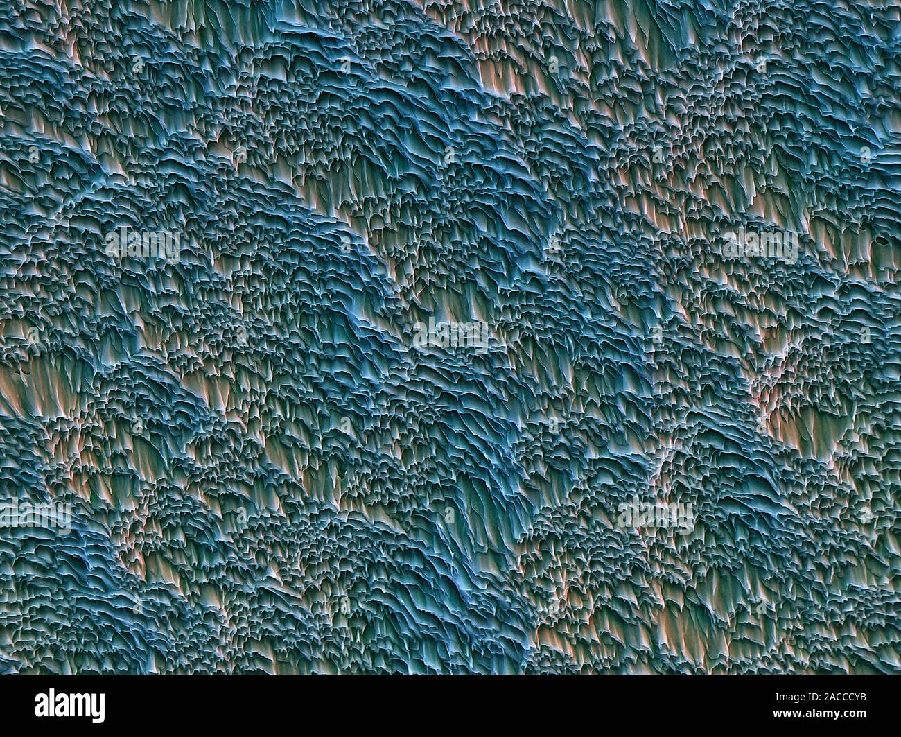 Etched plastic surface. Coloured scanning electron micrograph (SEM) of ...