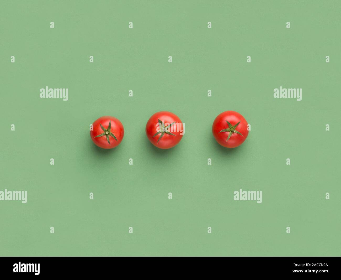 Red cherry tomatoes on light green background Stock Photo
