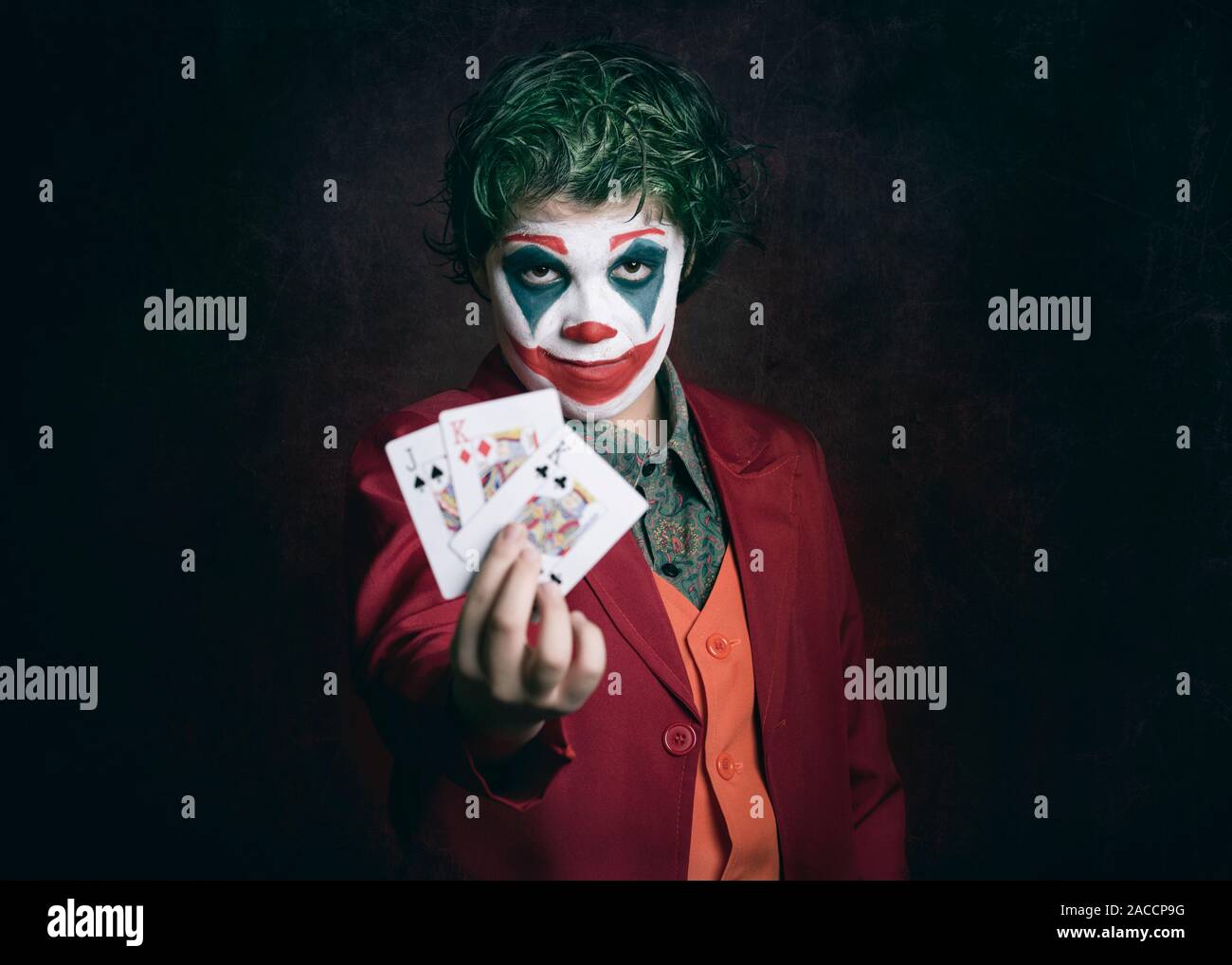 boy dressed as Joker with poker cards on dark background Stock Photo - Alamy