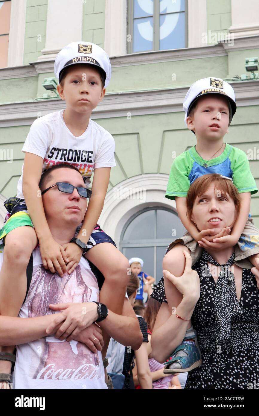 Saint-Petersburg, Russia, July 28 2019. Parents holding their sons on the shoulders during Navy Day celebration Stock Photo
