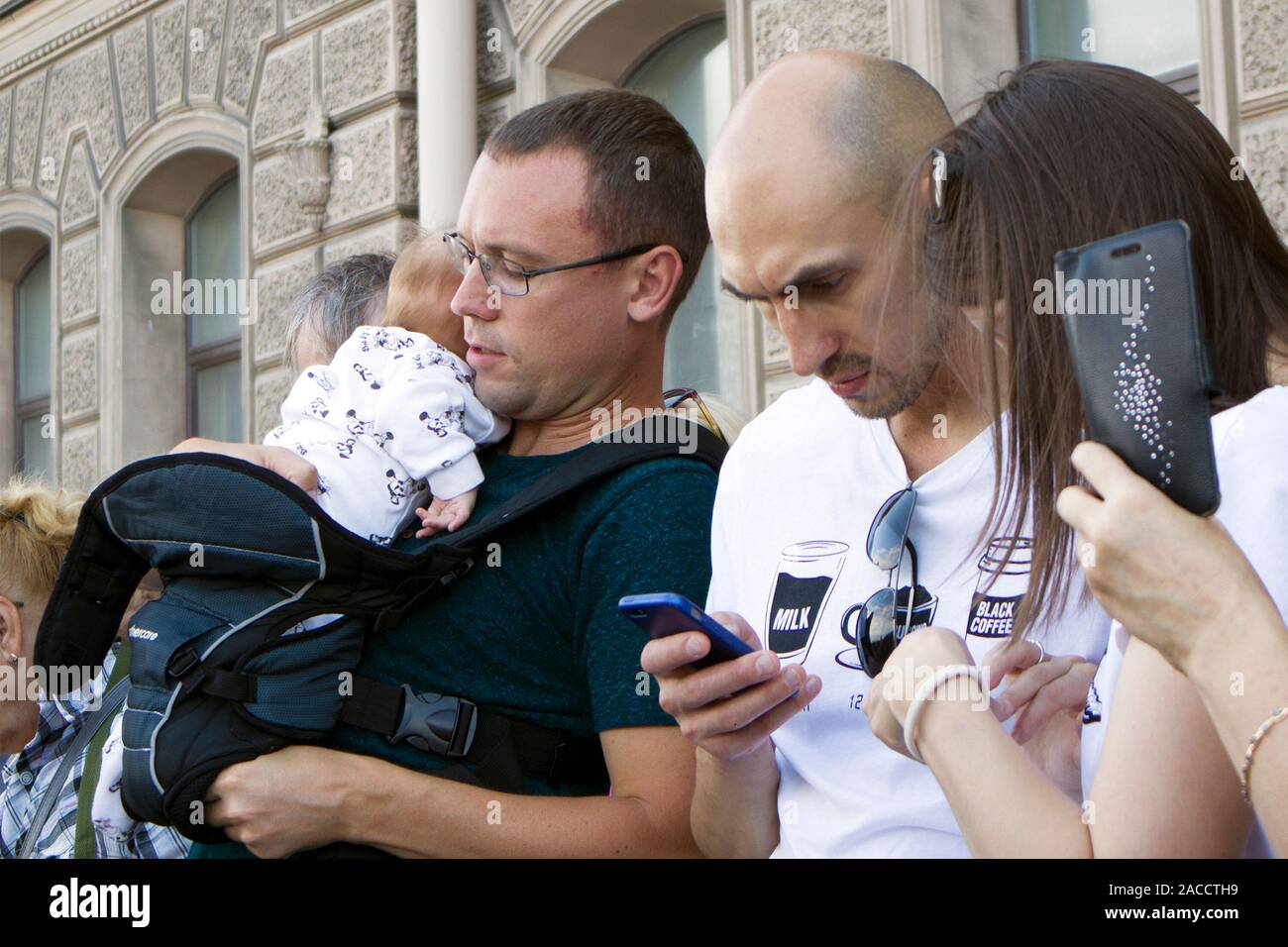 Saint-Petersburg, Russia, July 28 2019. Man with baby between crowd of people during Navy Day celebration Stock Photo