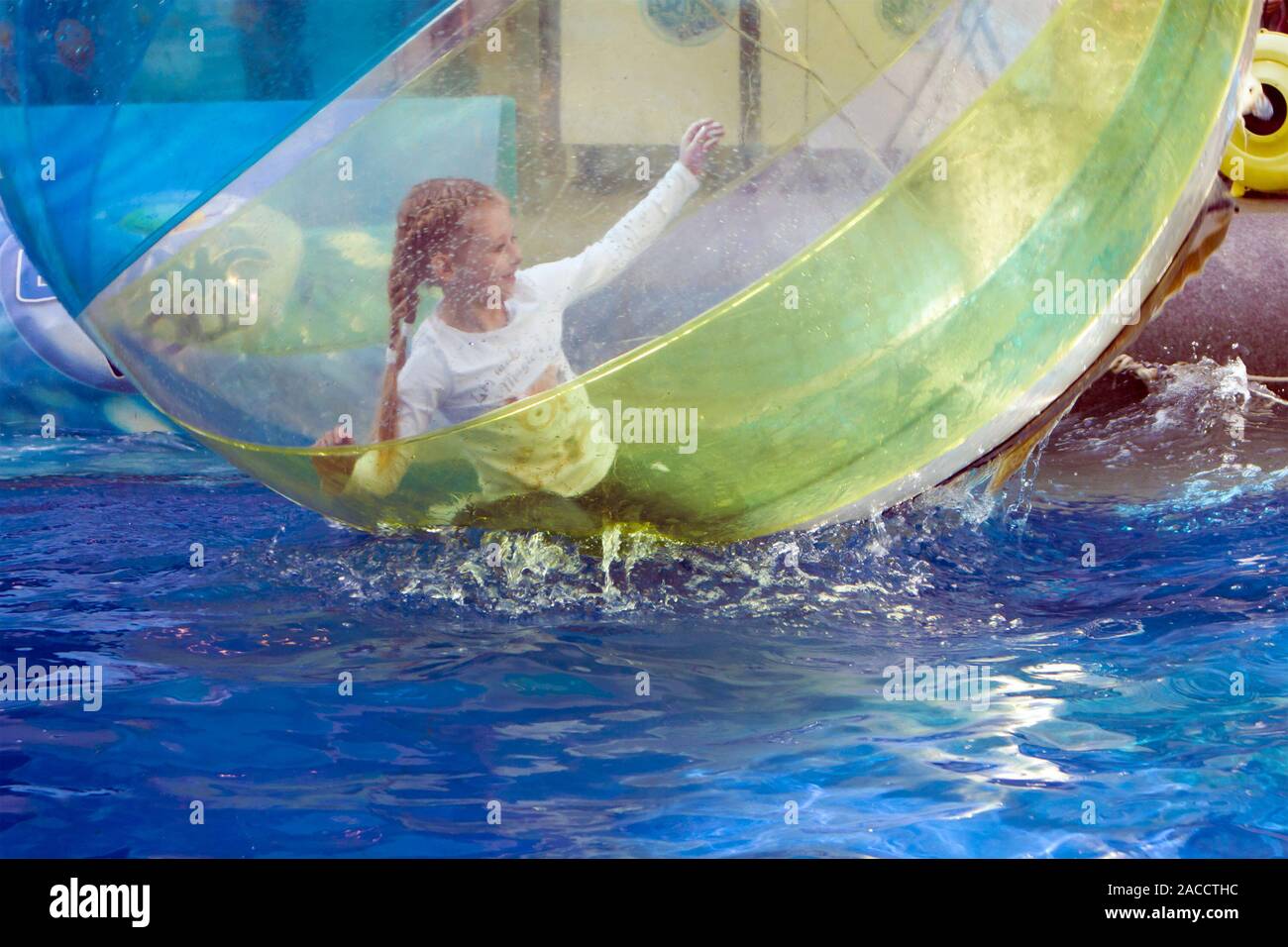 Saint-Petersburg, Russia, April 27, 2019. Little girl playing inside the big transparent water bubble in swimming pool Stock Photo