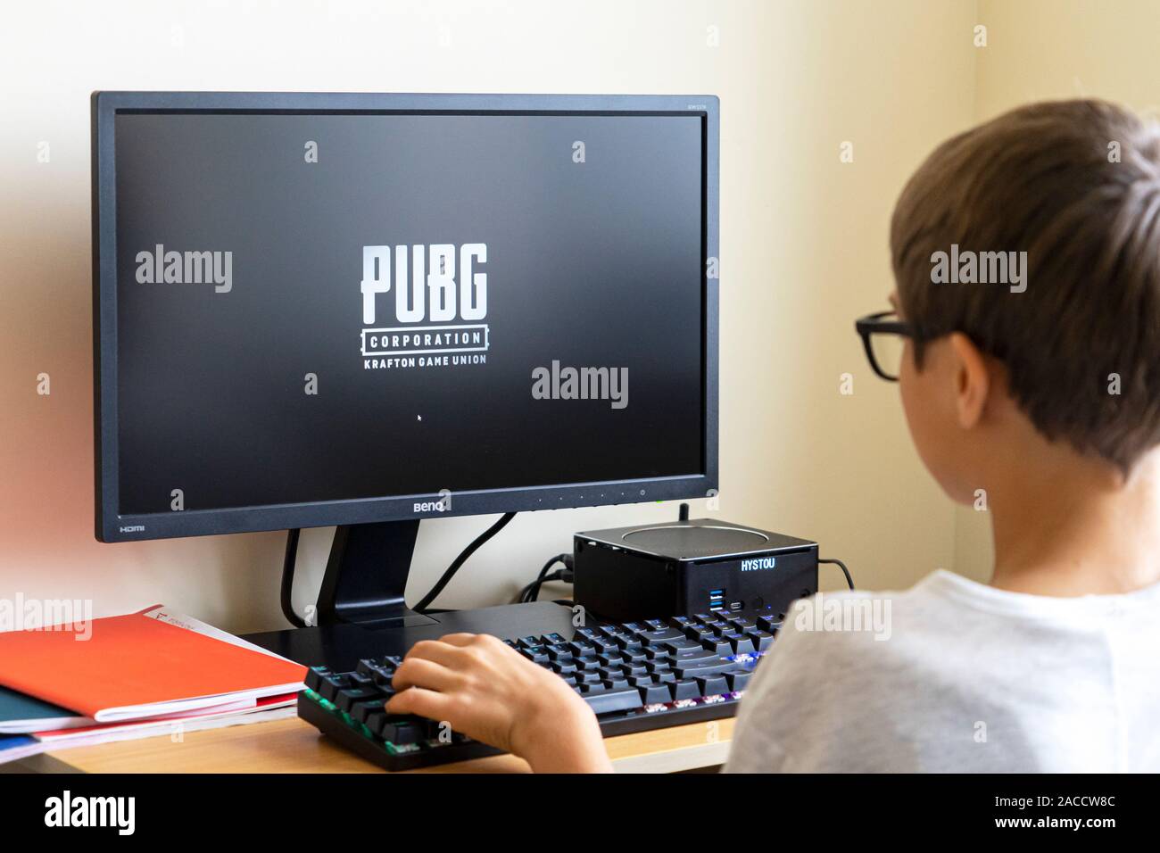 Boy playing PUBG Lite video game on PC at home. PUBG Lite is popular online video game. Vilnius, Lithuania - 19 October 2019 Stock Photo