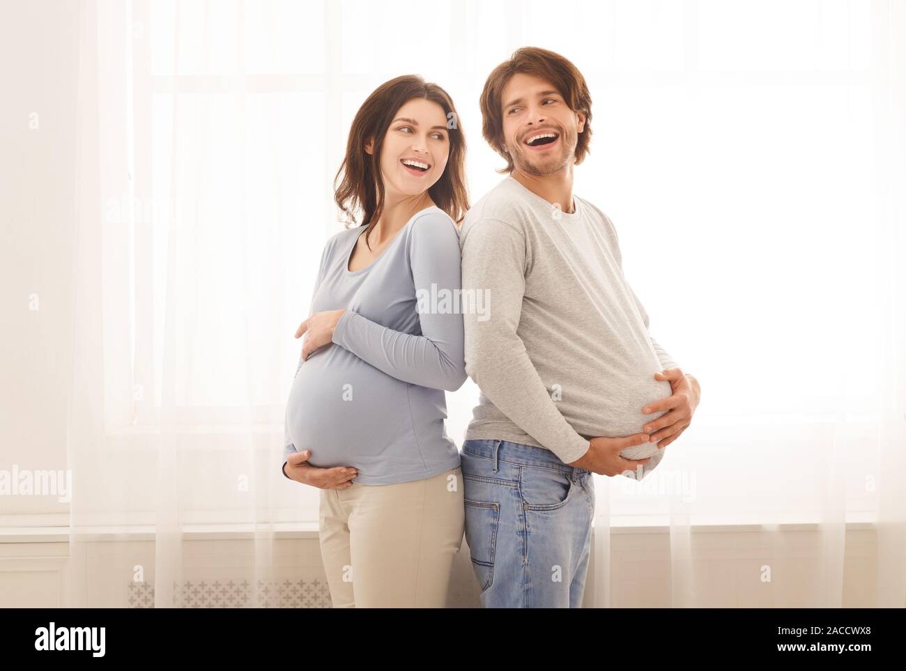 Portrait of funny man with fake belly and his pregnant wife Stock Photo -  Alamy