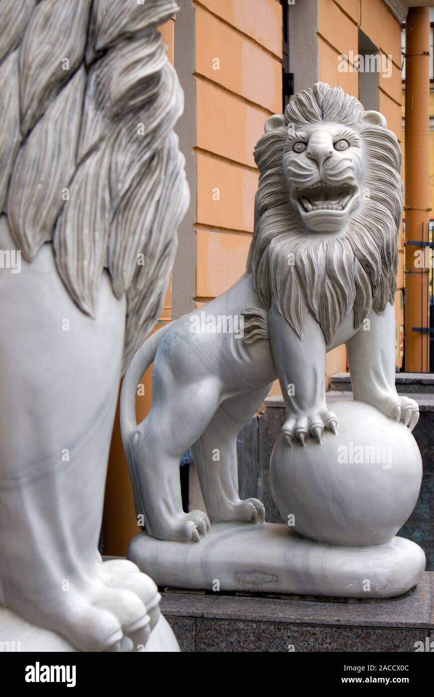 Funny marble smiling lion with ball statue in front of the Chinese restaurant Stock Photo
