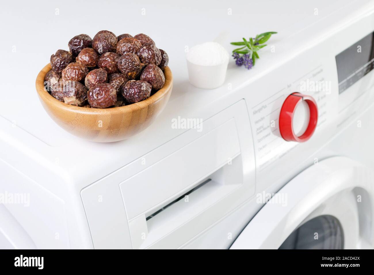 soap nuts in a bowl on the washing machine and lavender, detergent powder, selective focus Stock Photo