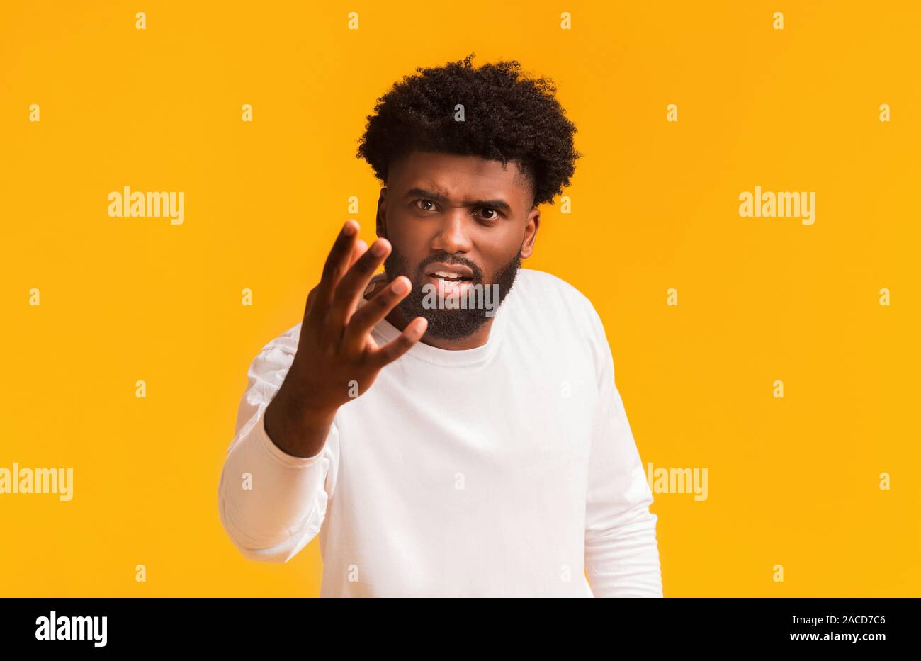 Angry black guy shouting and gesturing over orange background Stock Photo