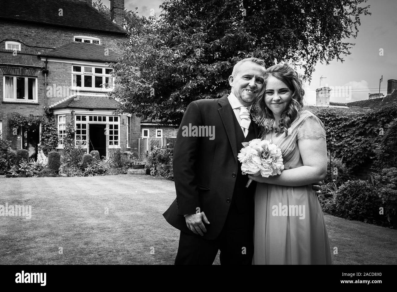 Bride, Groom and wedding guests pose for picture outside at the Manor hotel, B&B in Cheadle, Stoke on Trent, Staffordshire, Wedding day Stock Photo