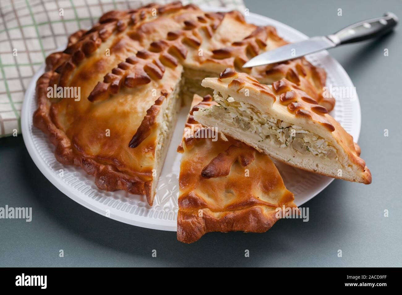 Close-up homemade cabbage pie on a cutting board. Russian and Ukrainian traditional national cuisine. Food Delivery Concept Stock Photo