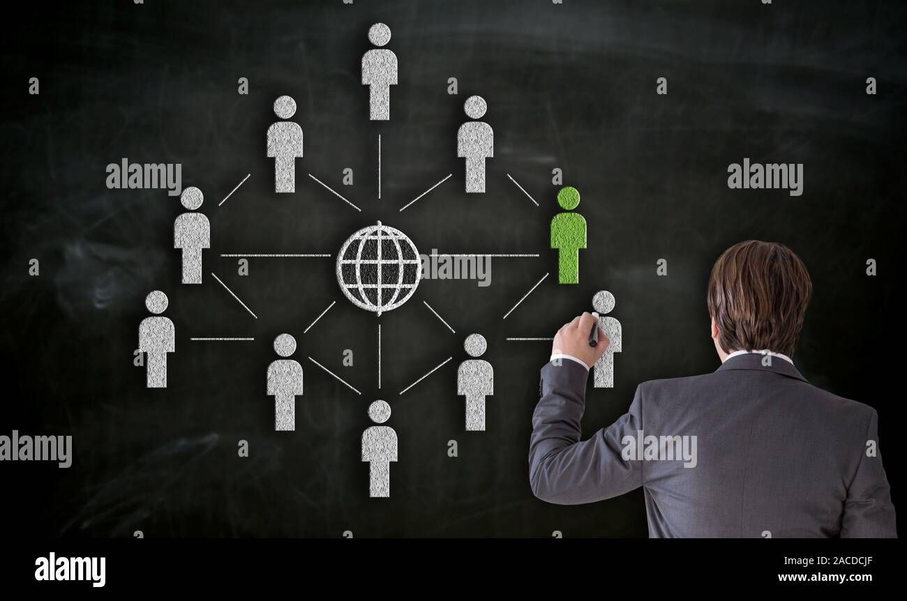 Businessman paints with chalk network concept on blackboard. Stock Photo