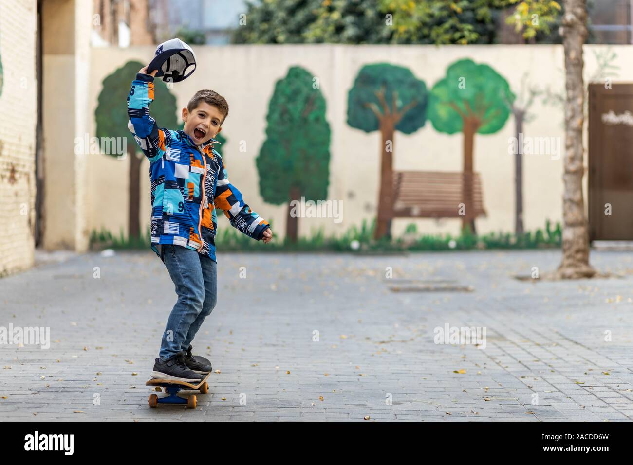 Euphoric little kid riding on his skateboard Stock Photo - Alamy