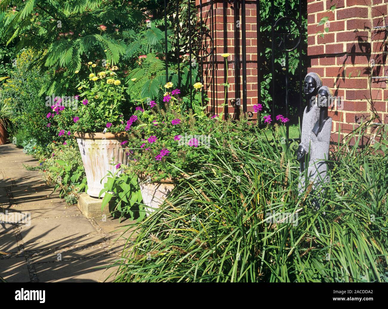 Walled garden. Verbena 'Homestead Purple' and Zinnia 'Early Double', yellow, in pots in a walled garden at RHS Wisley, UK. Stock Photo