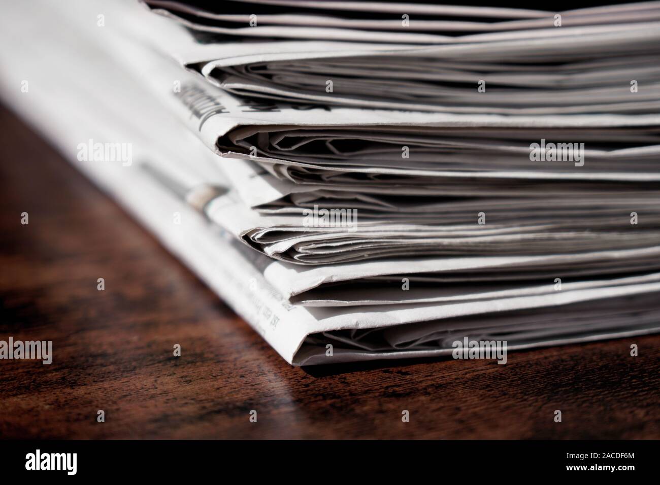 pile of newspapers or papers on wooden table - print media news Stock Photo
