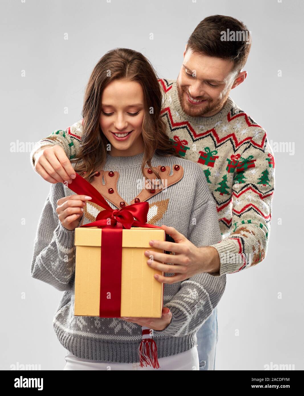 happy couple in christmas sweaters with gift box Stock Photo Alamy