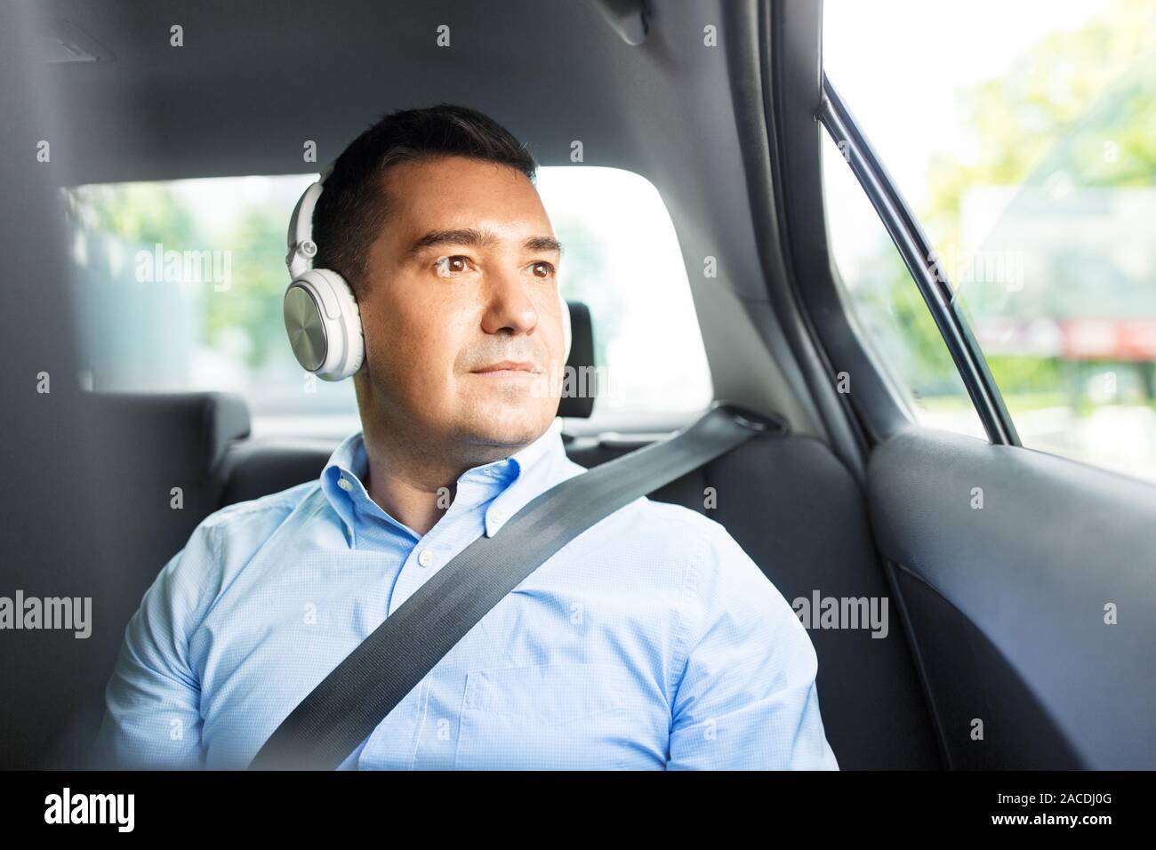passenger in headphones listening to music in car Stock Photo Alamy
