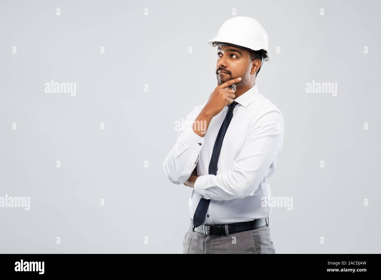 indian male architect in helmet over grey Stock Photo