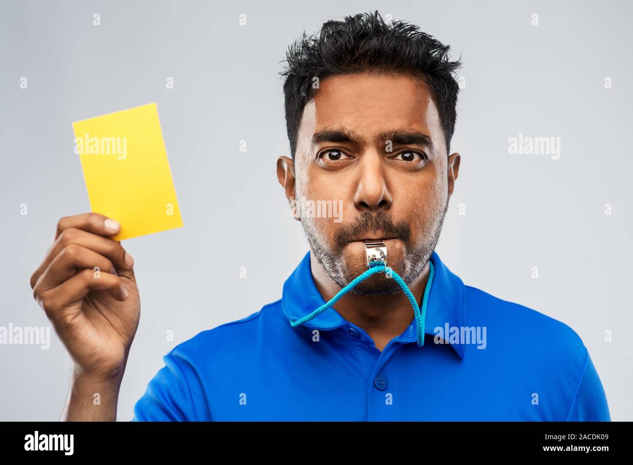 indian referee whistling and showing yellow card Stock Photo