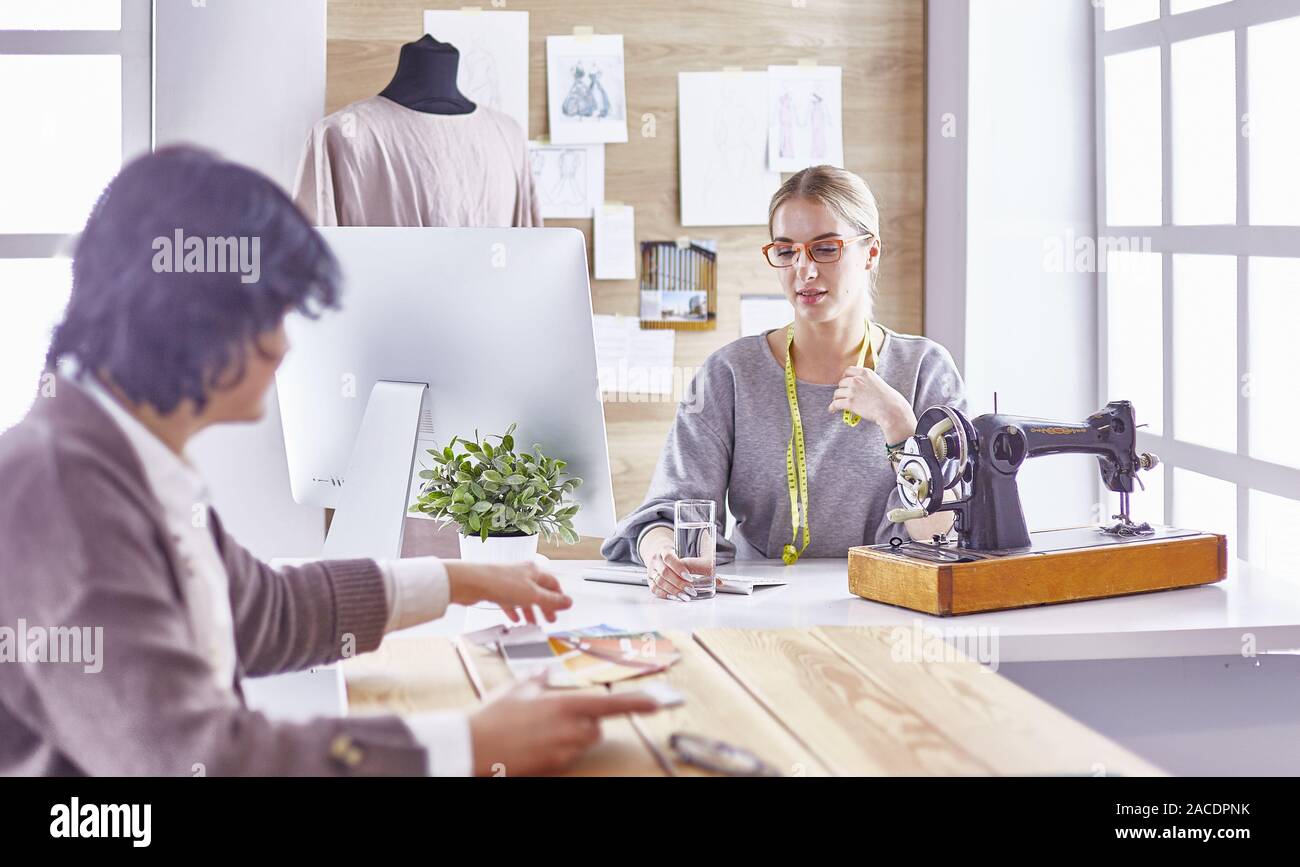 pretty dressmaker showing a new design to her client Stock Photo - Alamy