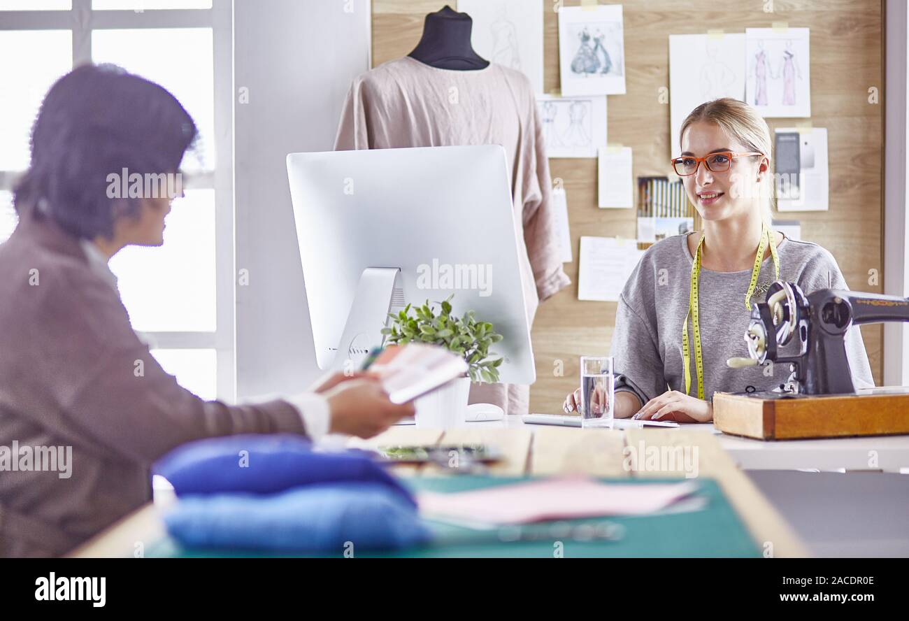 pretty dressmaker showing a new design to her client Stock Photo - Alamy