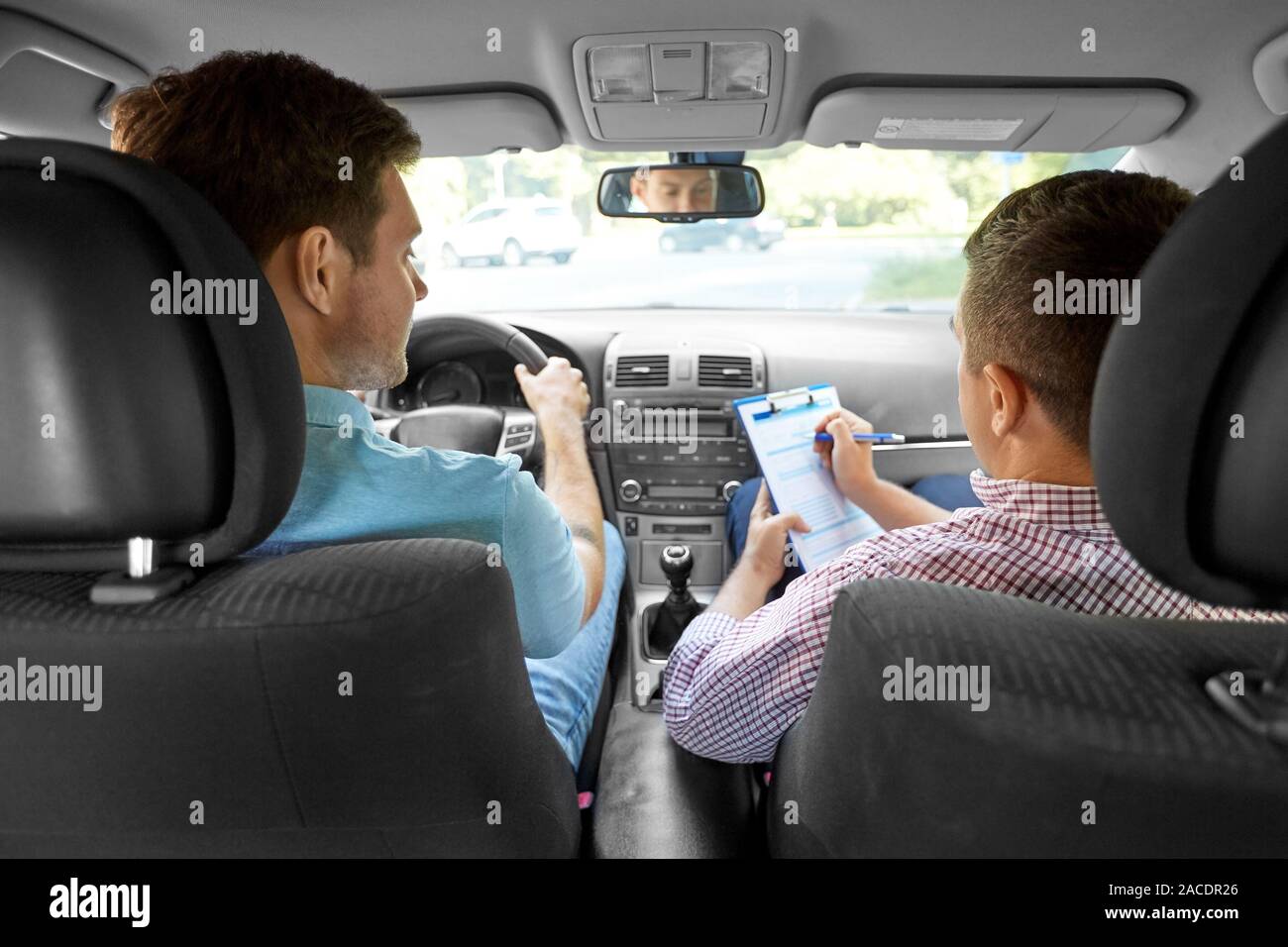 car driving instructor with clipboard and driver Stock Photo - Alamy