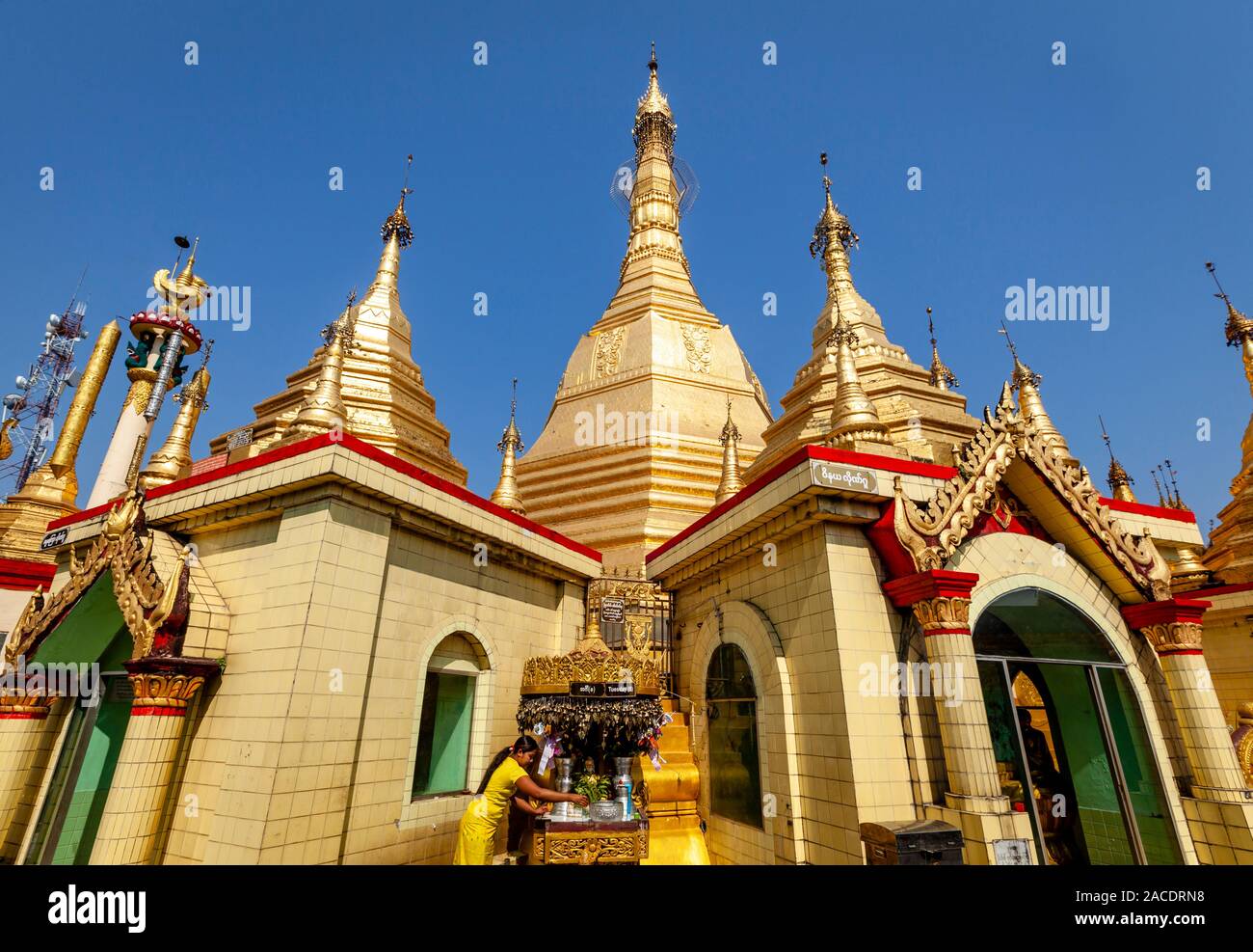 A Young Woman Pouring A Cup Of Water Over A Small Buddha Statue, Sule Pagoda, Yangon, Myanmar. Stock Photo
