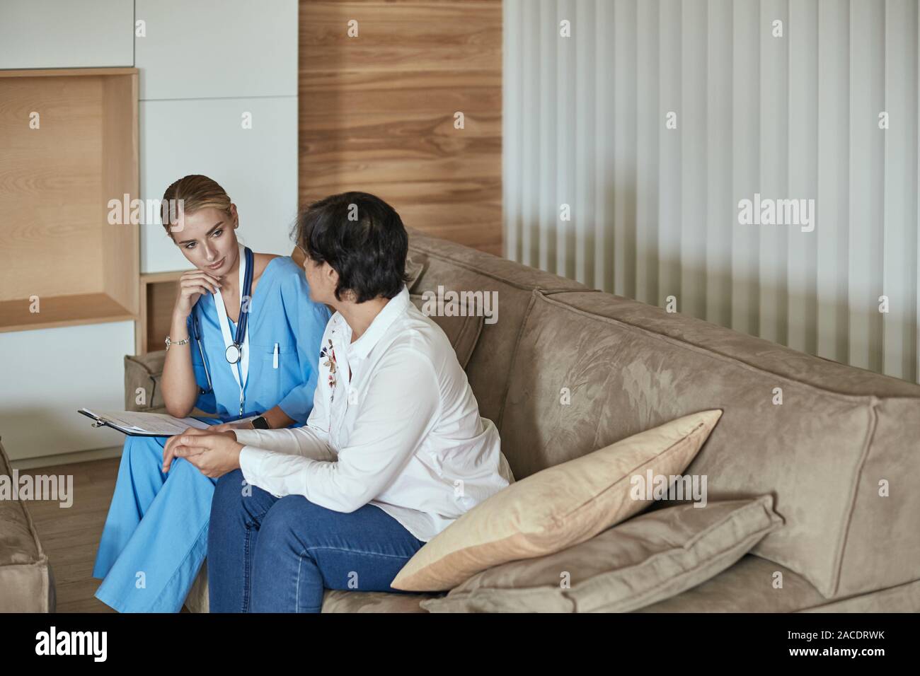 Friendly Smiling Doctor And Patient Sitting On The Couch Very