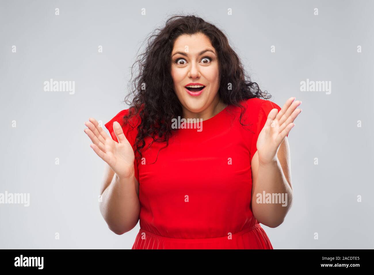 happy surprised woman in red dress Stock Photo - Alamy