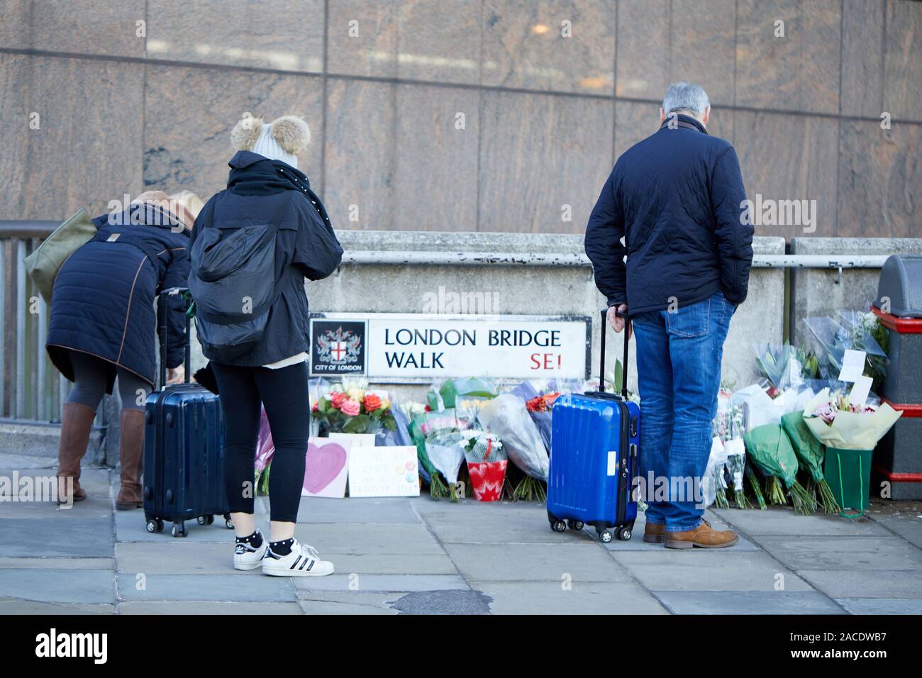 London, U.K. - Dec 2, 2019: Passers-by stop to read tributes left for the victims of the London Bridge terrorist attack, three days after the incident. Stock Photo