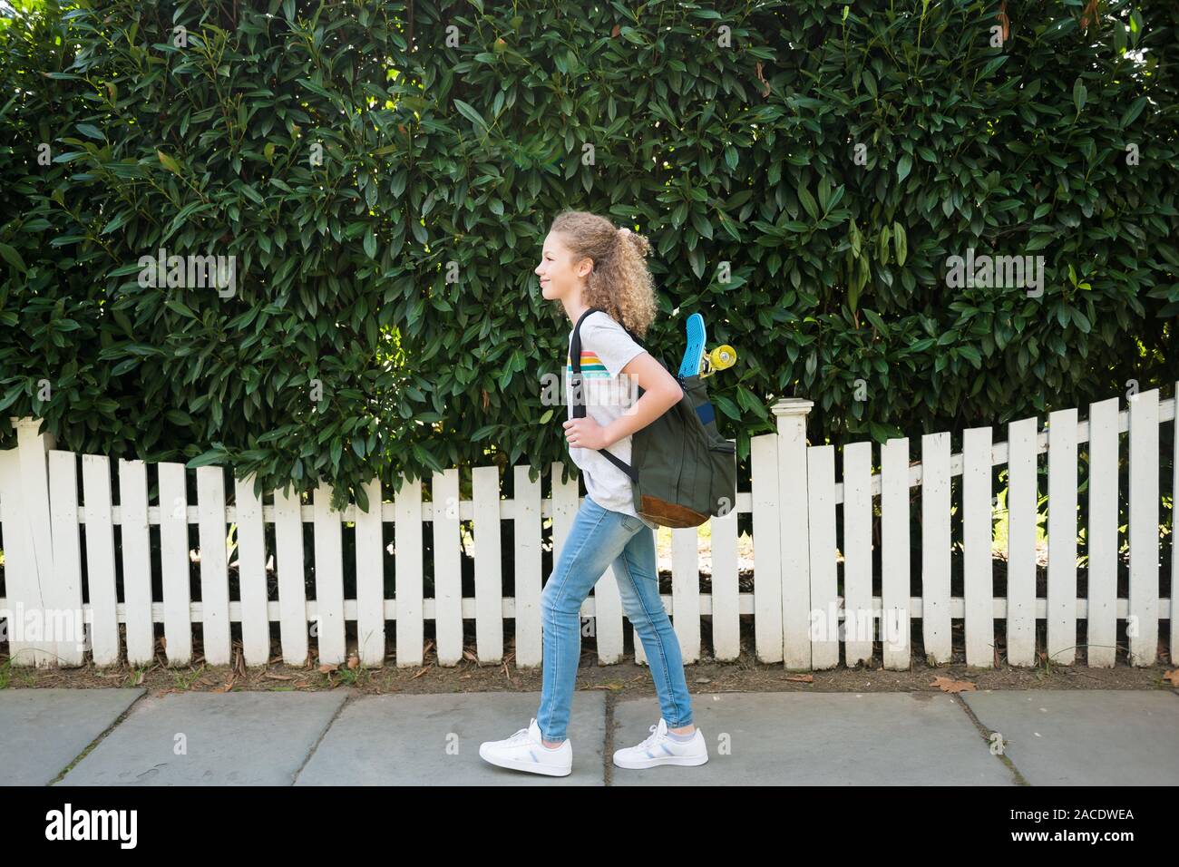 Girl with skateboard in backpack Stock Photo Alamy