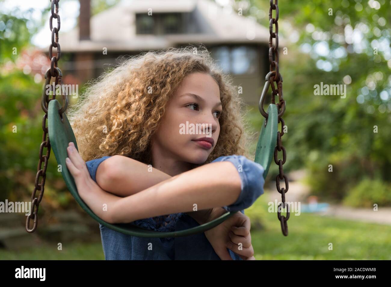 Girl leaning on swing Stock Photo