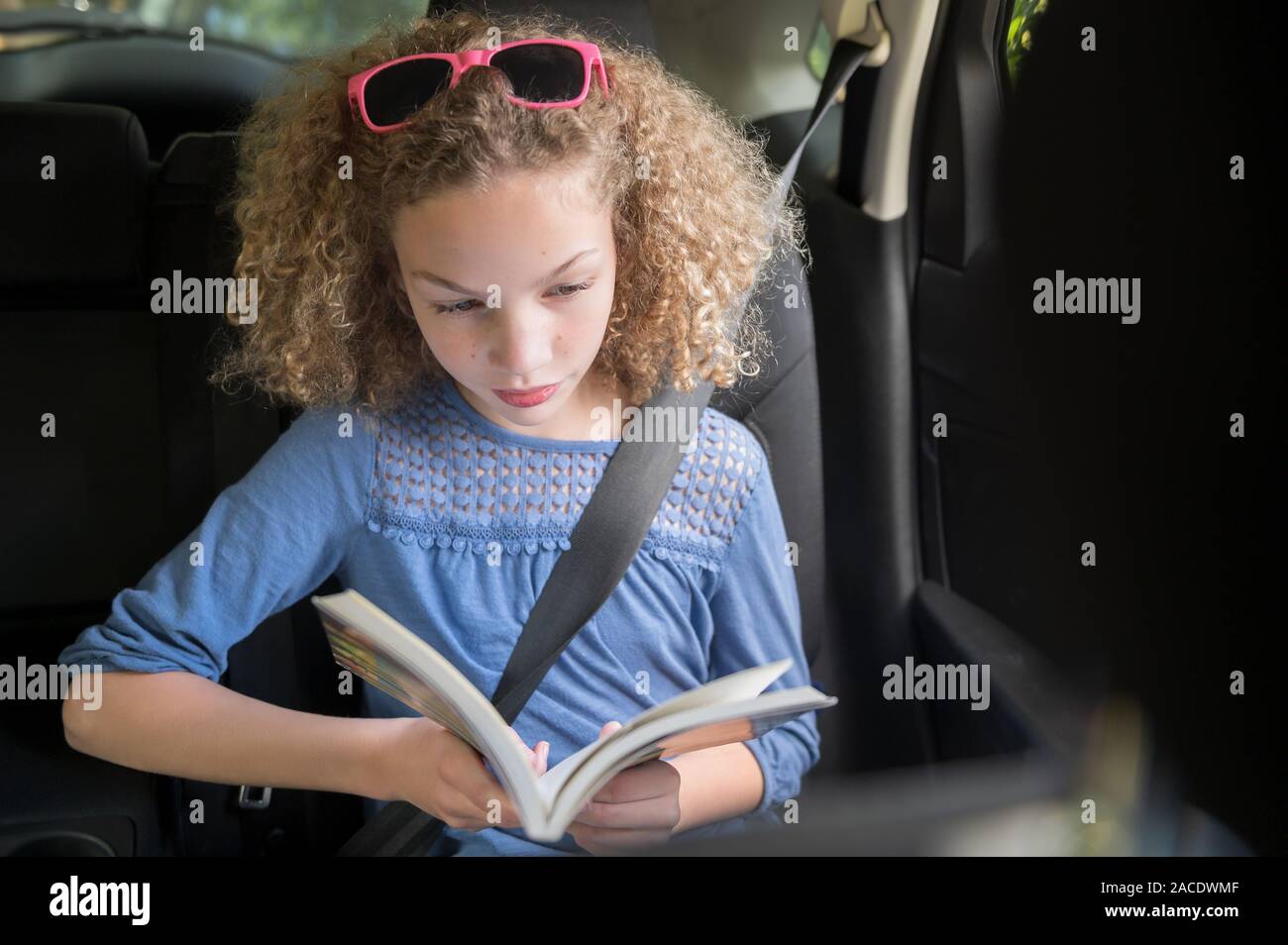 Girl reading book in car Stock Photo Alamy