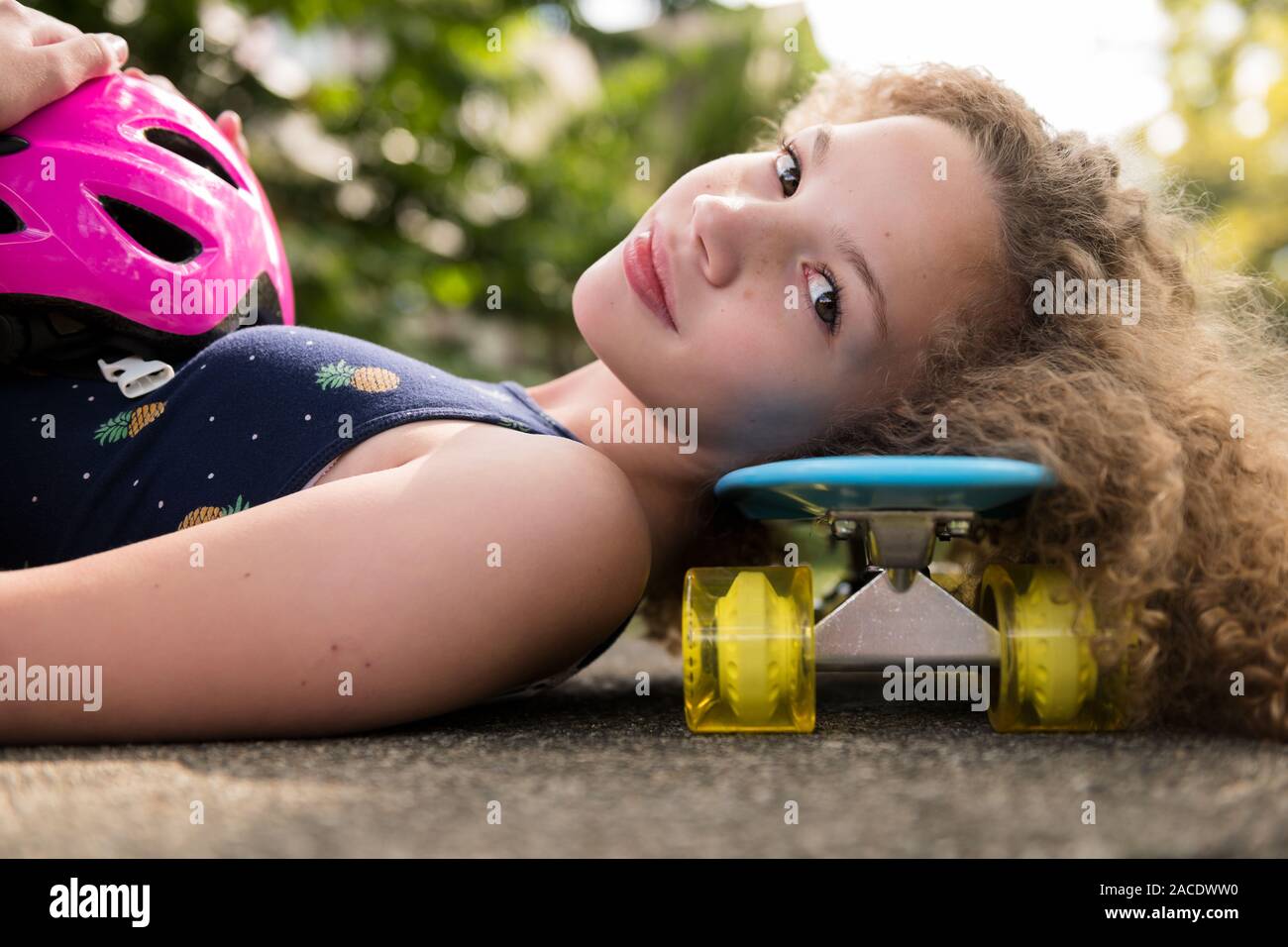Girl lying on skateboard Stock Photo