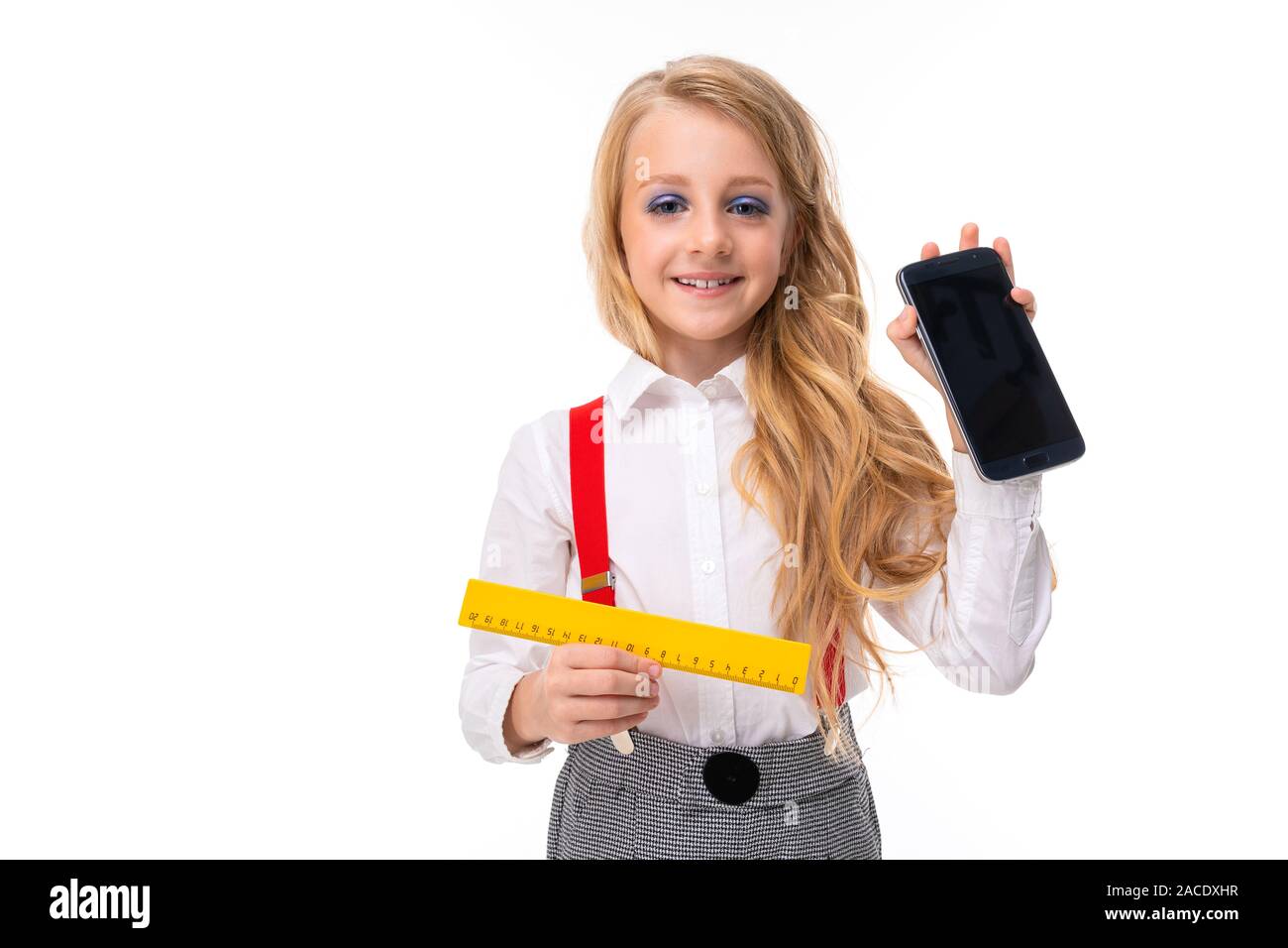 European girl with a ruler and a phone with a breadboard in her hands ...