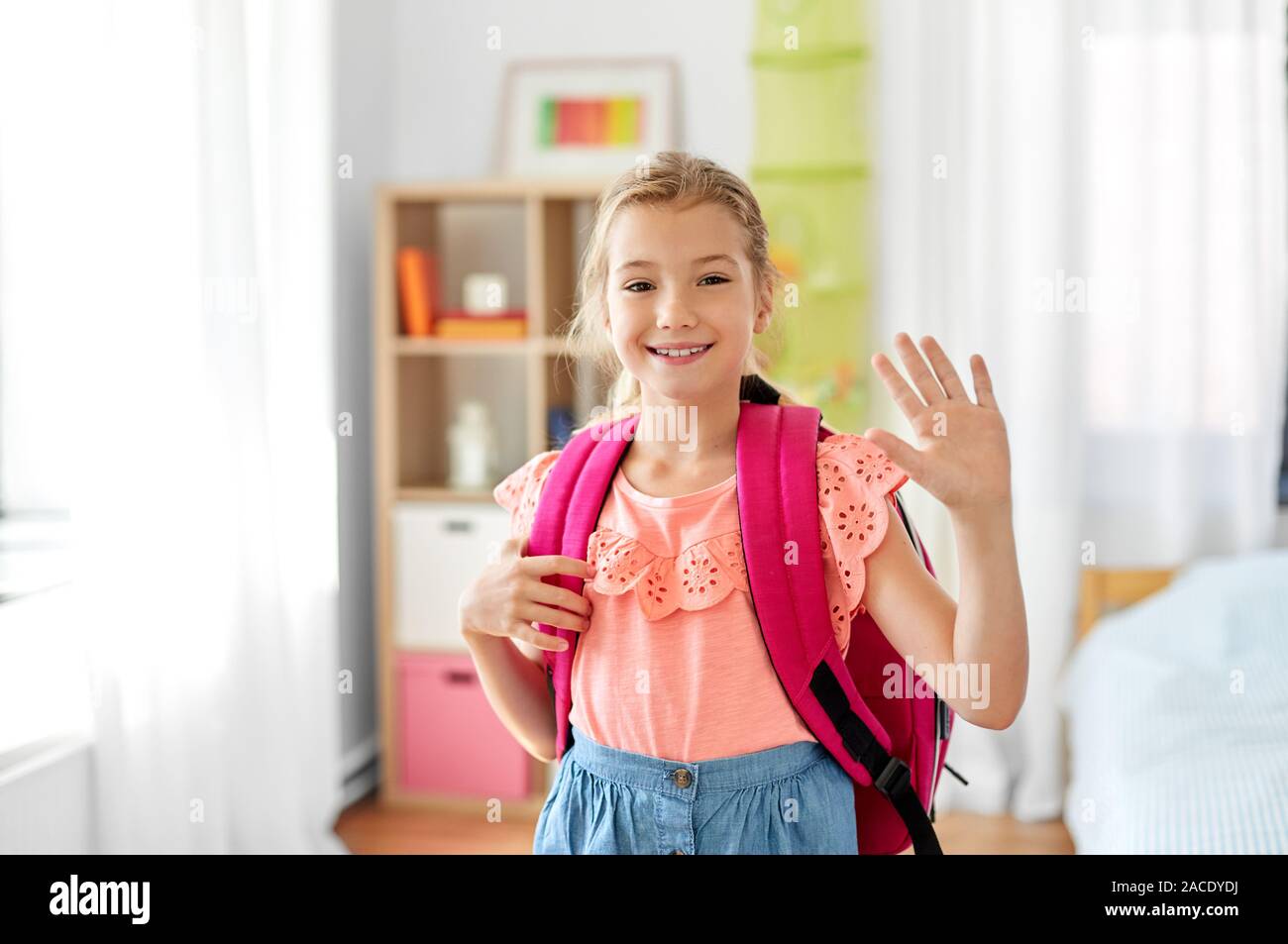 student girl with school bag at home waving hand Stock Photo - Alamy