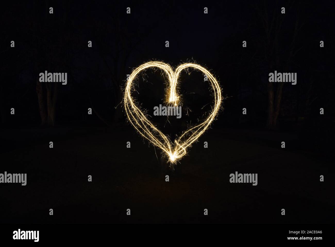 heart shape light painting with sparklers outdoors at night - symbol for love and romance Stock Photo