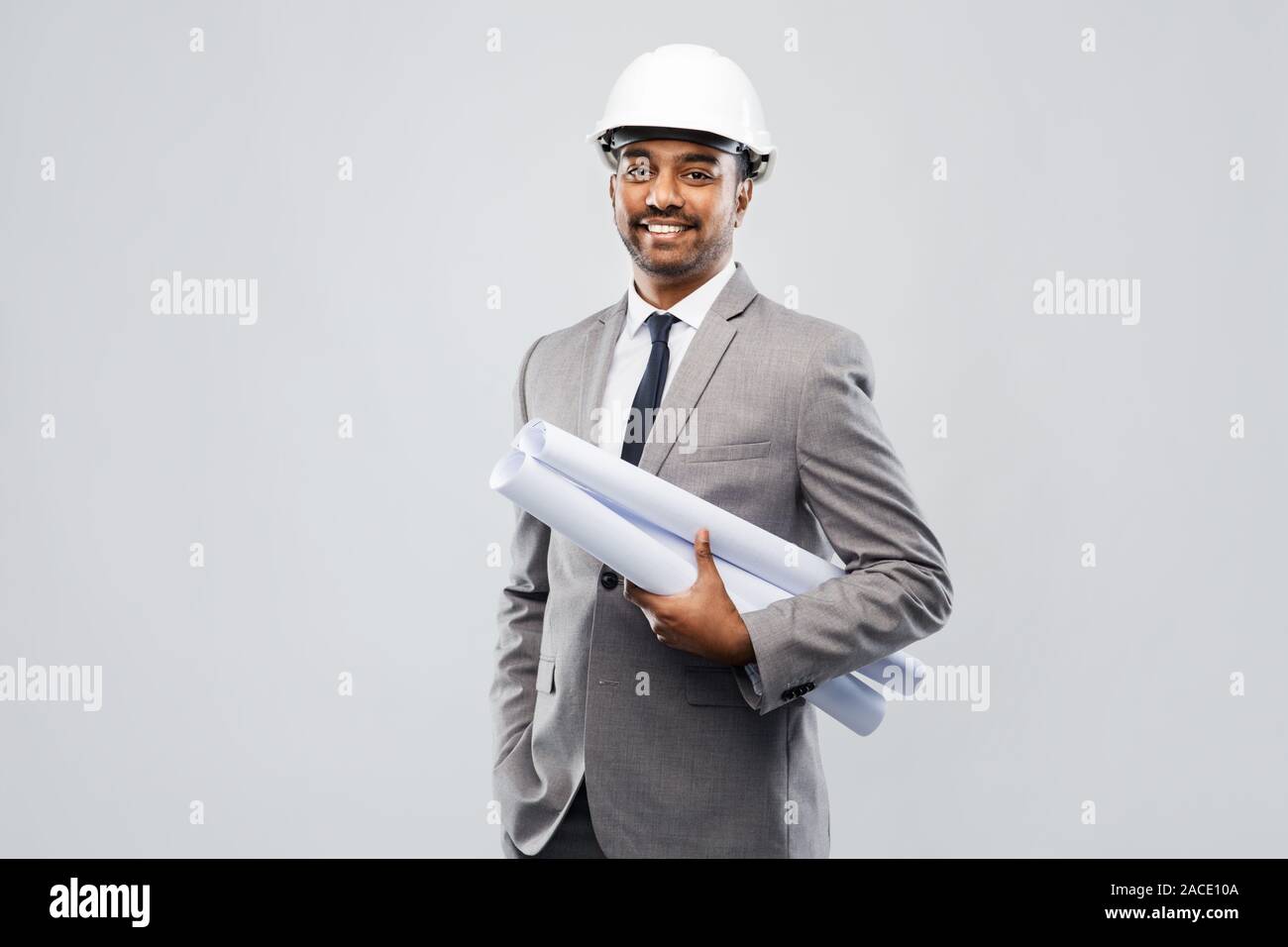 indian male architect in helmet with blueprints Stock Photo