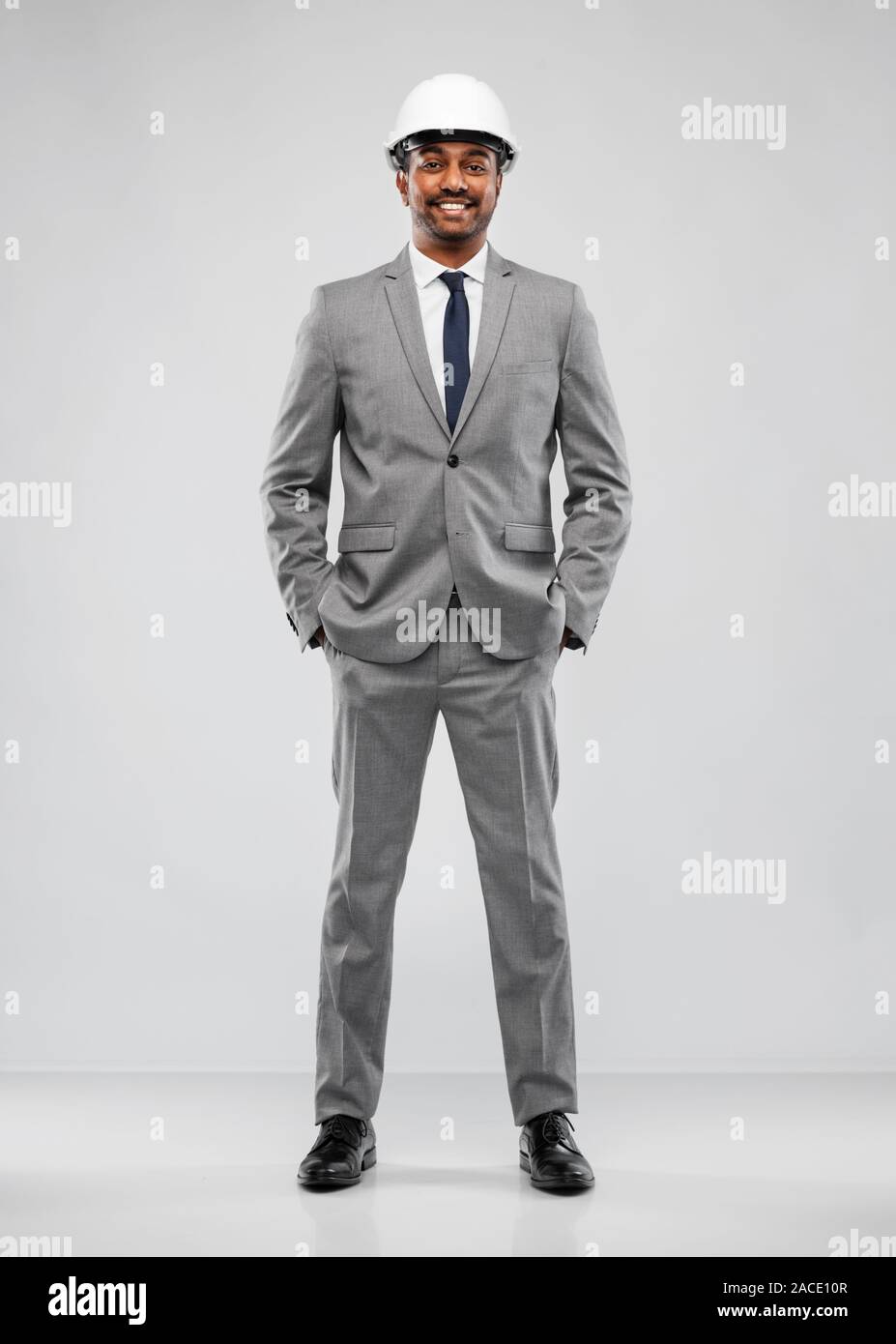 indian male architect in helmet over grey Stock Photo