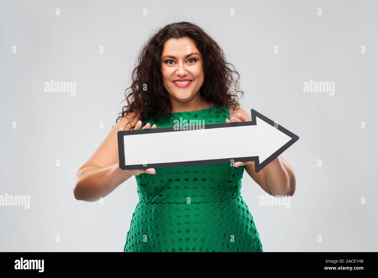happy woman in green dress with rightwards arrow Stock Photo - Alamy