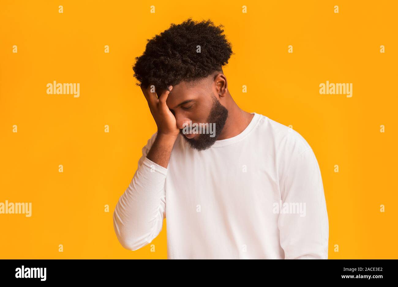 Upset black guy covering his face with hand Stock Photo - Alamy