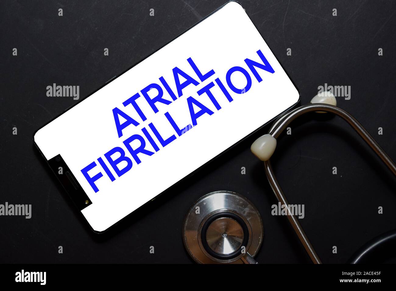 Atrial Fibrillation text on smartphone. Top view isolated on black background. Healthcare/Medical concept Stock Photo