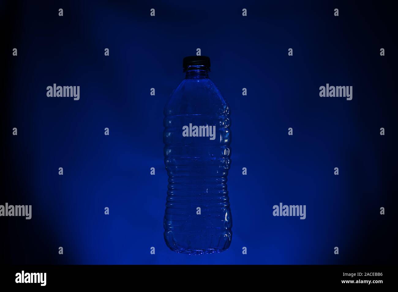 Silhouette of used plastic bottle on dark background Stock Photo