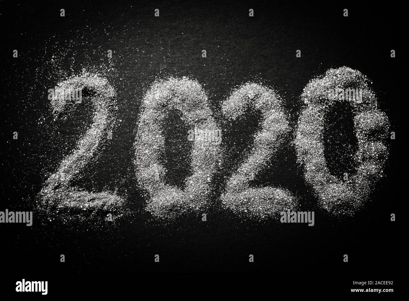2020 shiny silver sparkles pattern on black table. Stock Photo