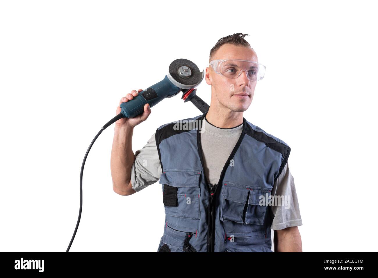 Builder in safety glasses with angle grinder on his shoulder. Stock Photo